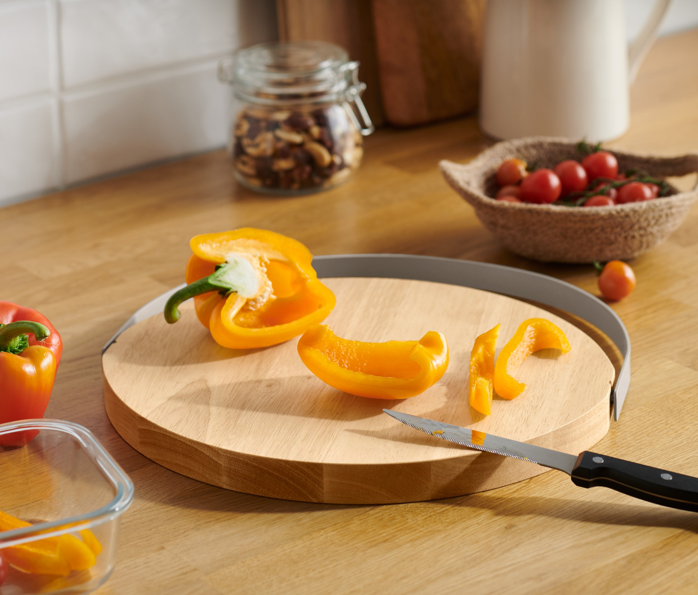 Żółta papryka jest krojona na drewnianej desce do krojenia.