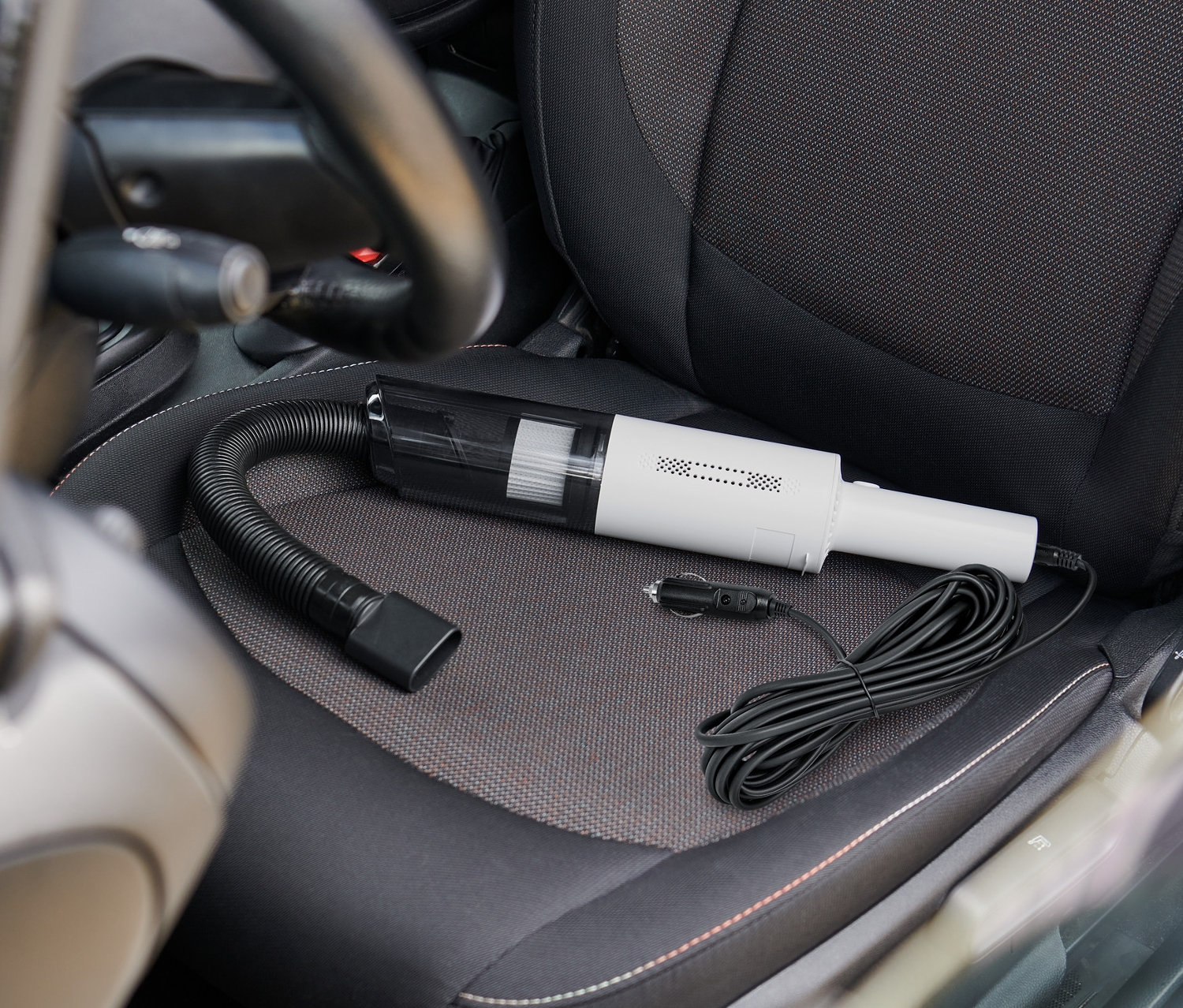 Odkurzacz samochodowy leży na siedzeniu samochodu.