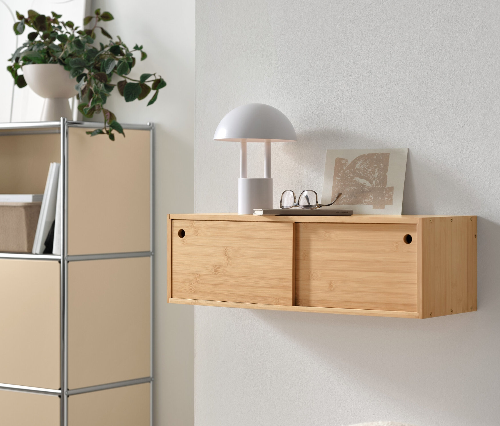 Półka ścienna z przesuwnymi drzwiami obok metalowej komody „CN3” z 2 klapami.