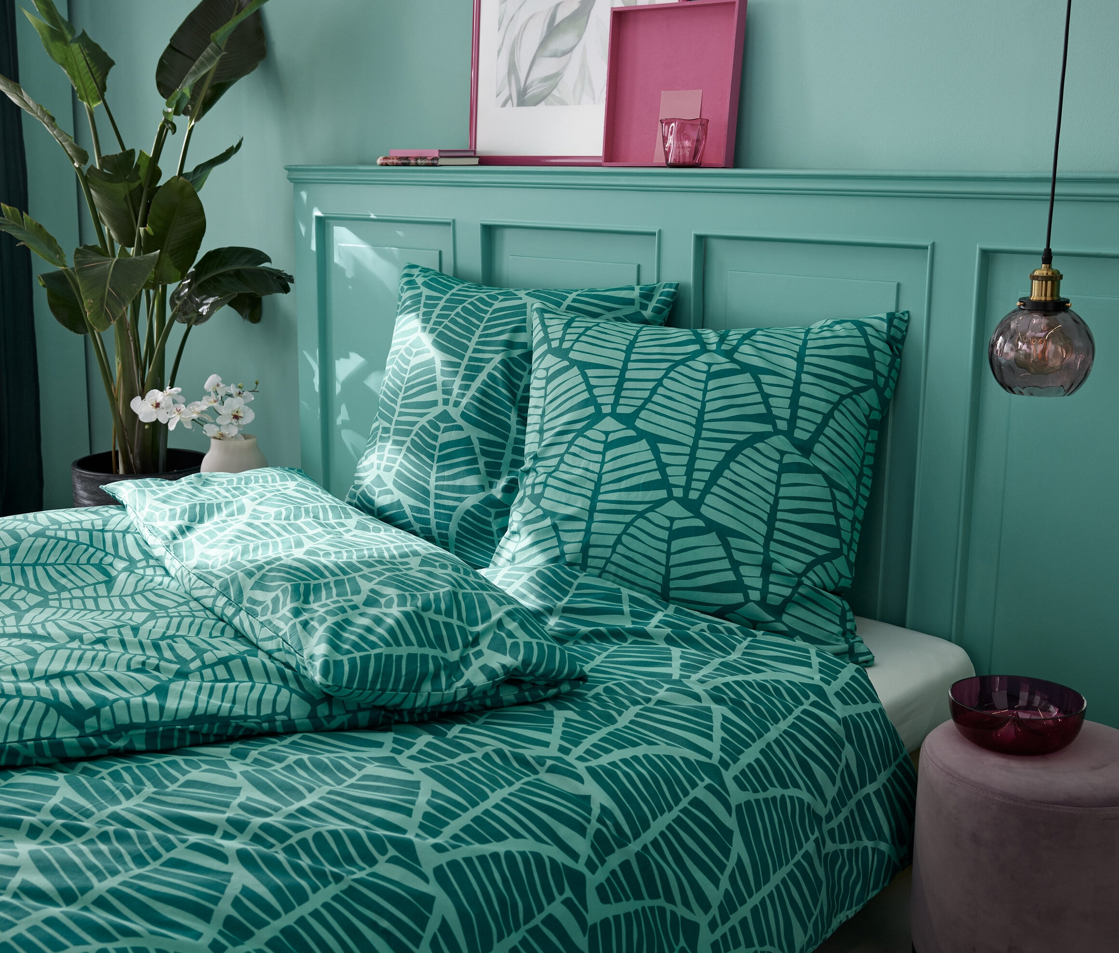 Zielona pościel z bawełny renforcé w rozmiarze standardowym i niestandardowym z nadrukiem liści na łóżku.
