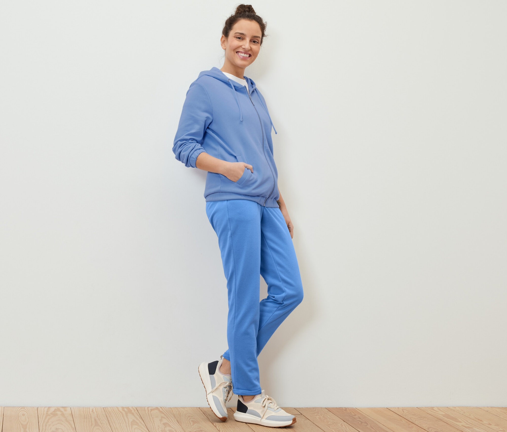 Kobieta pozuje w jasnoniebieskiej bluzie.