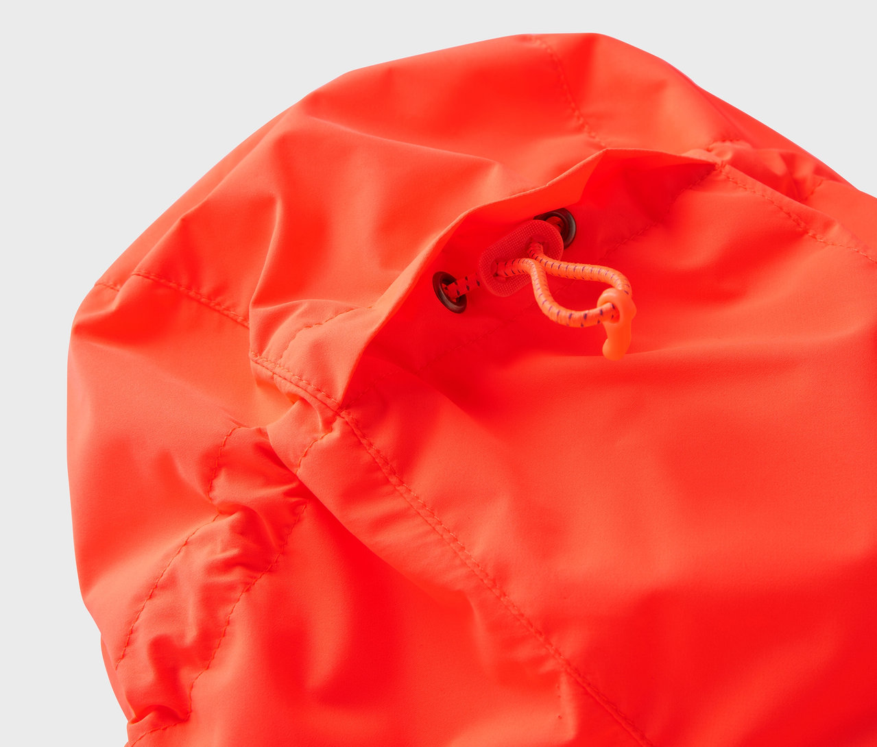 Zbliżenie na kaptur pomarańczowej kurtki ze sznurkiem.