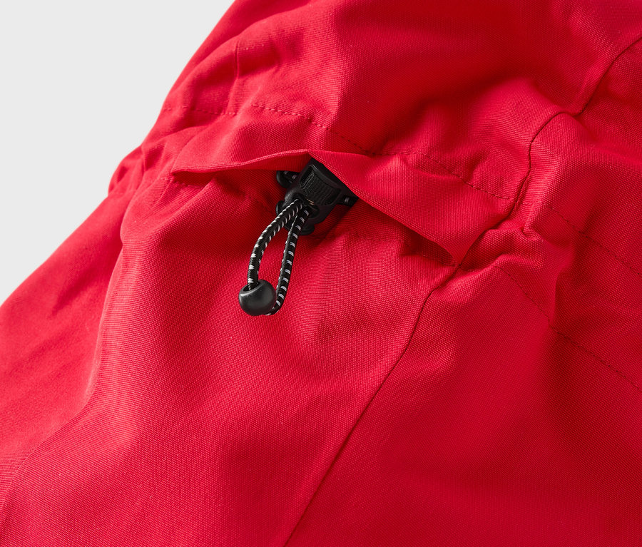 Detal czerwonej kurtki z kapturem i sznurkiem.