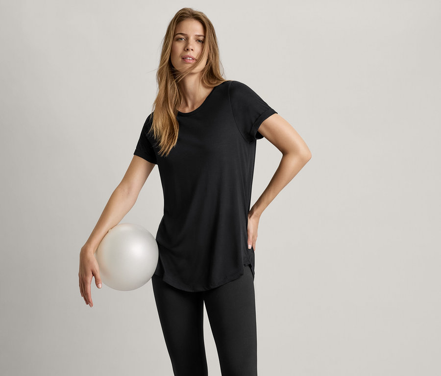 Kobieta trzyma piłkę i ma na sobie czarną długą koszulkę.