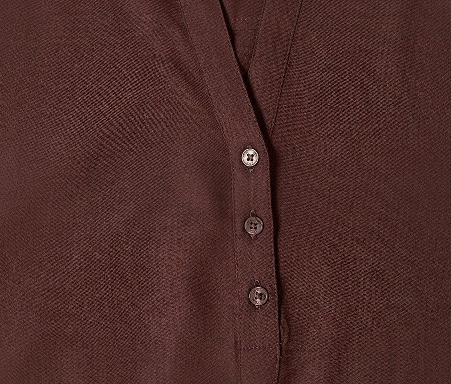 Zbliżenie na brązową bluzkę tunikową CECIL z dekoltem w serek i trzema guzikami.