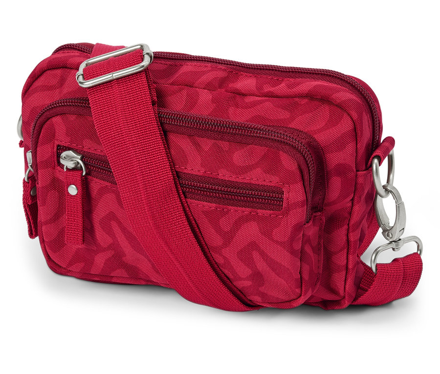 Czerwona antykradzieżowa torba na ramię lub biodra z zamkami i regulowanym paskiem leży na białym tle.