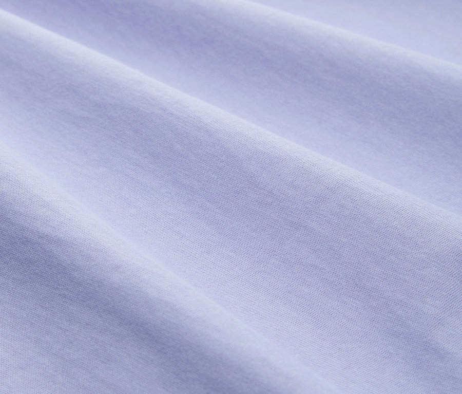 Zbliżenie draperia jasnoniebieskiego materiału o subtelnej teksturze.