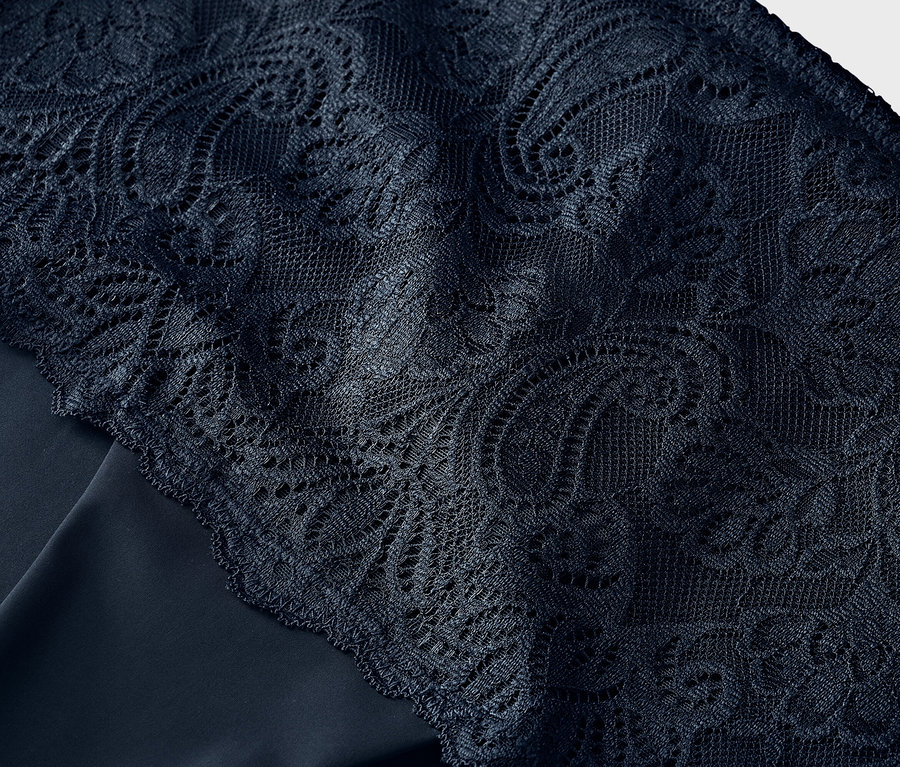 Zbliżenie granatowej koronki na granatowej tkaninie.