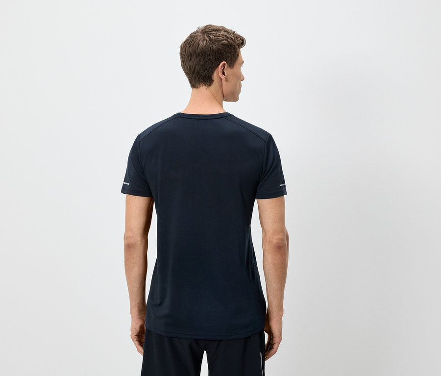 Mężczyzna od tyłu ma na sobie granatową koszulkę i czarne szorty na białym tle.