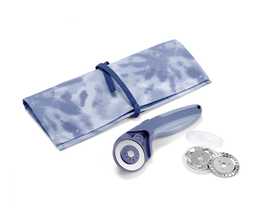 Nóż krążkowy do cięcia tkanin leży obok materiałowego etui ze sznurkiem.