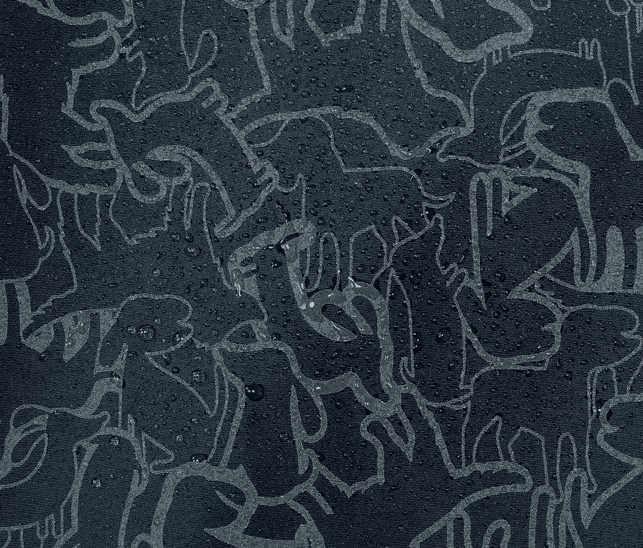 Zbliżenie na dziecięcą termoaktywną kurtkę przeciwdeszczową z elementami odblaskowymi i wzorem zwierzęcym, na której znajdują się krople wody.