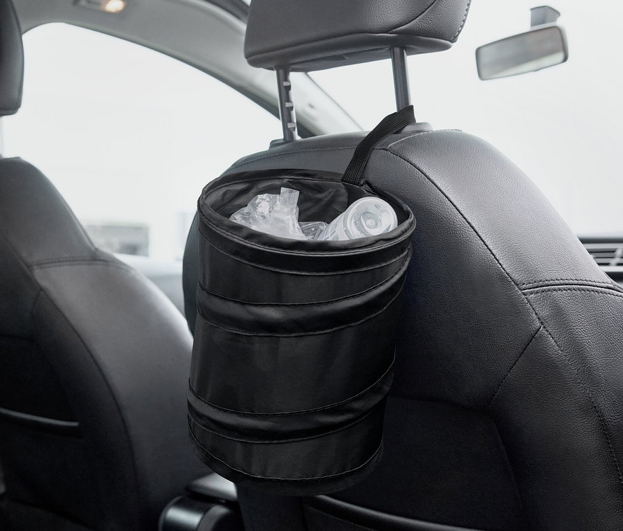 Czarny składany kosz na śmieci wisi na tylnej części siedzenia samochodowego.