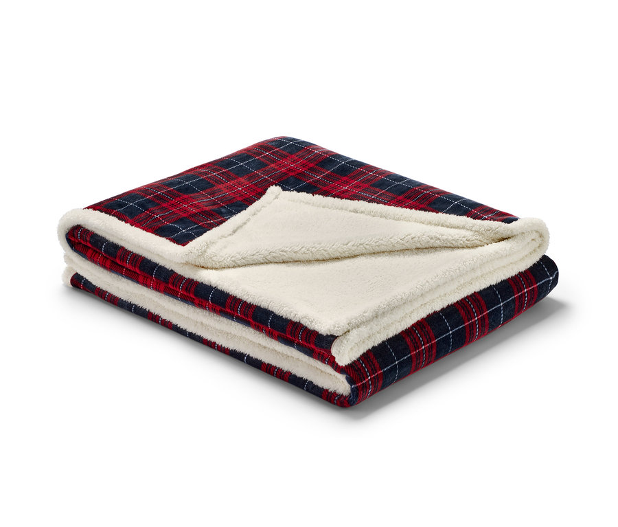 Złożony dwustronny ciepły koc z czerwono-niebiesko-białą kratą i kremową podszewką sherpa.