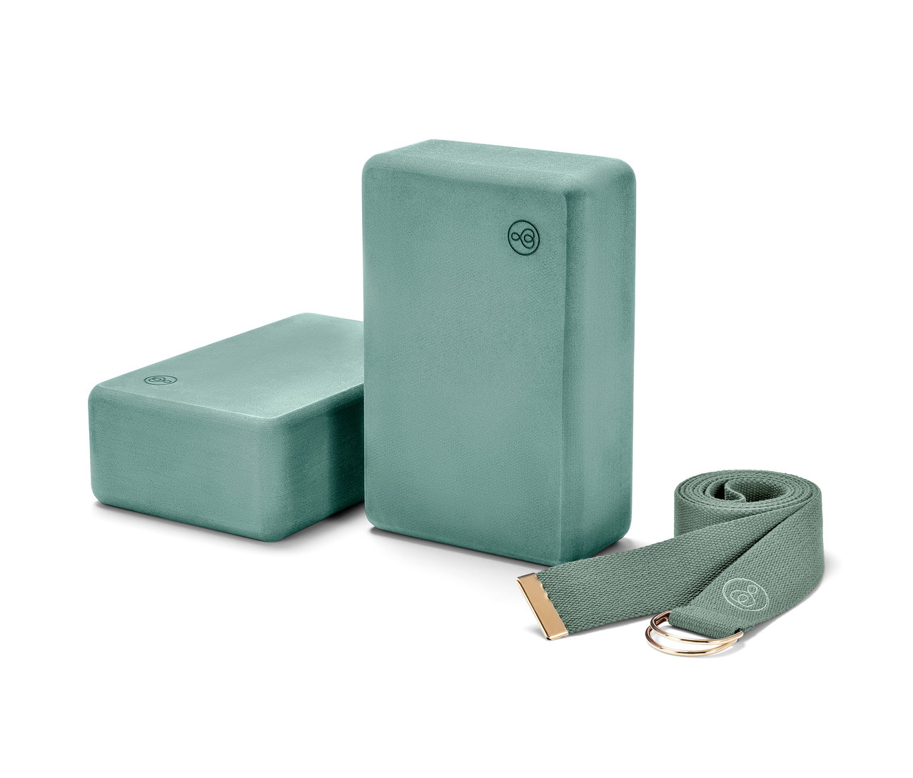 Dwa bloki do jogi i pasek do jogi z zestawu do jogi, wszystko w kolorze turkusowym.