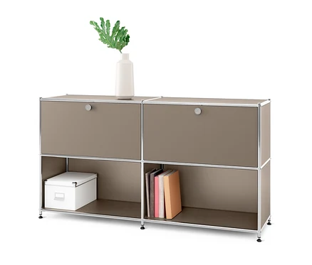 Szarobeżowa metalowa szafka typu sideboard »CN3« z 2 klapami do indywidualnego umieszczenia. Na górze wazon z rośliną, na dole książki i białe pudełko.