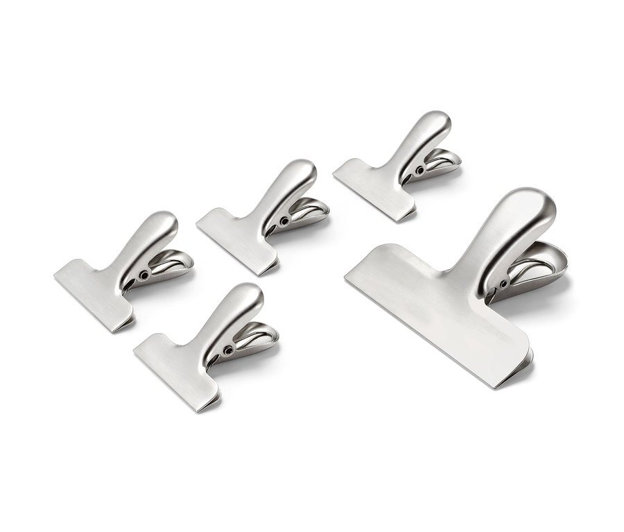 Pięć klipsów ze stali nierdzewnej na białym tle.