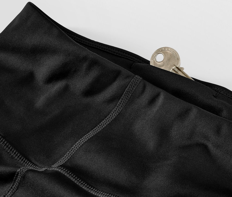 Zbliżenie na czarne legginsy sportowe z kluczem w kieszeni.