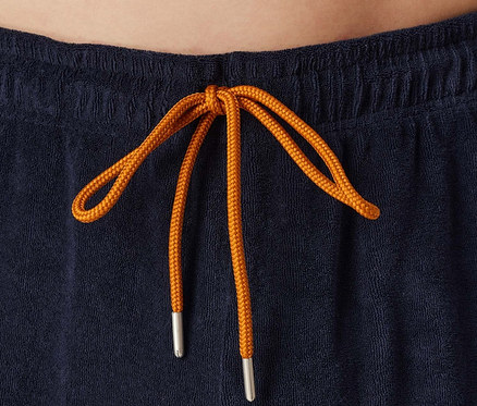 Szczegół granatowych szortów ze sznurkiem w kolorze pomarańczowym.