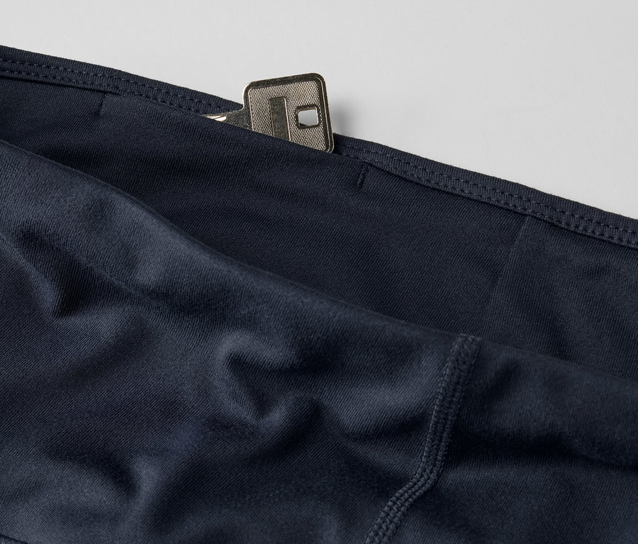 Zbliżenie na granatowe krótkie legginsy sportowe z kluczem w kieszeni.