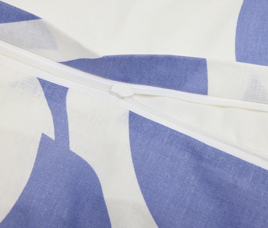 Zbliżenie zamka błyskawicznego na niebiesko-białej wzorzystej tkaninie.