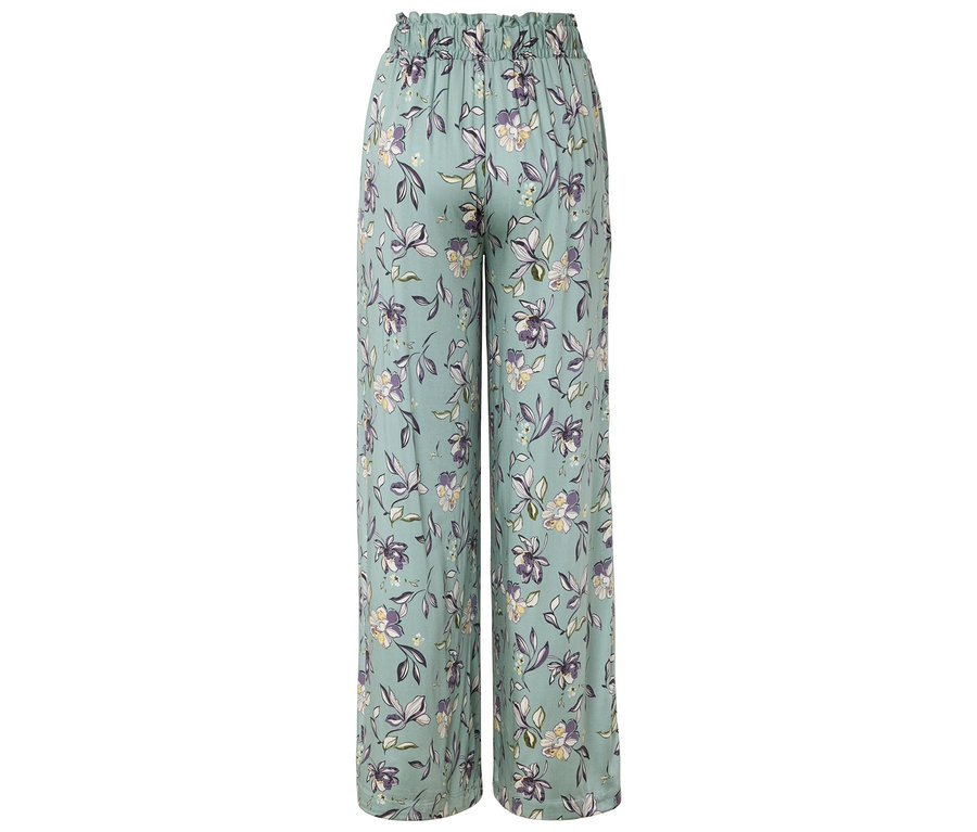 Jasno-niebieskie, szerokie spodnie we wzory kwiatowe, widziane od tyłu.