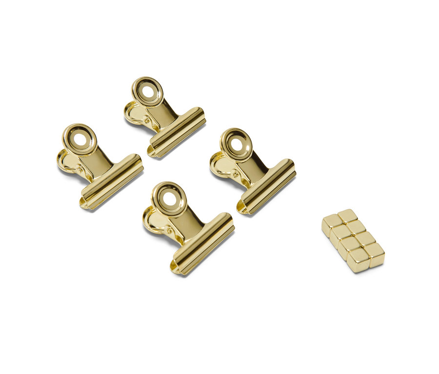 Cztery złote klipsy magnetyczne i zestaw magnesów na białym tle.