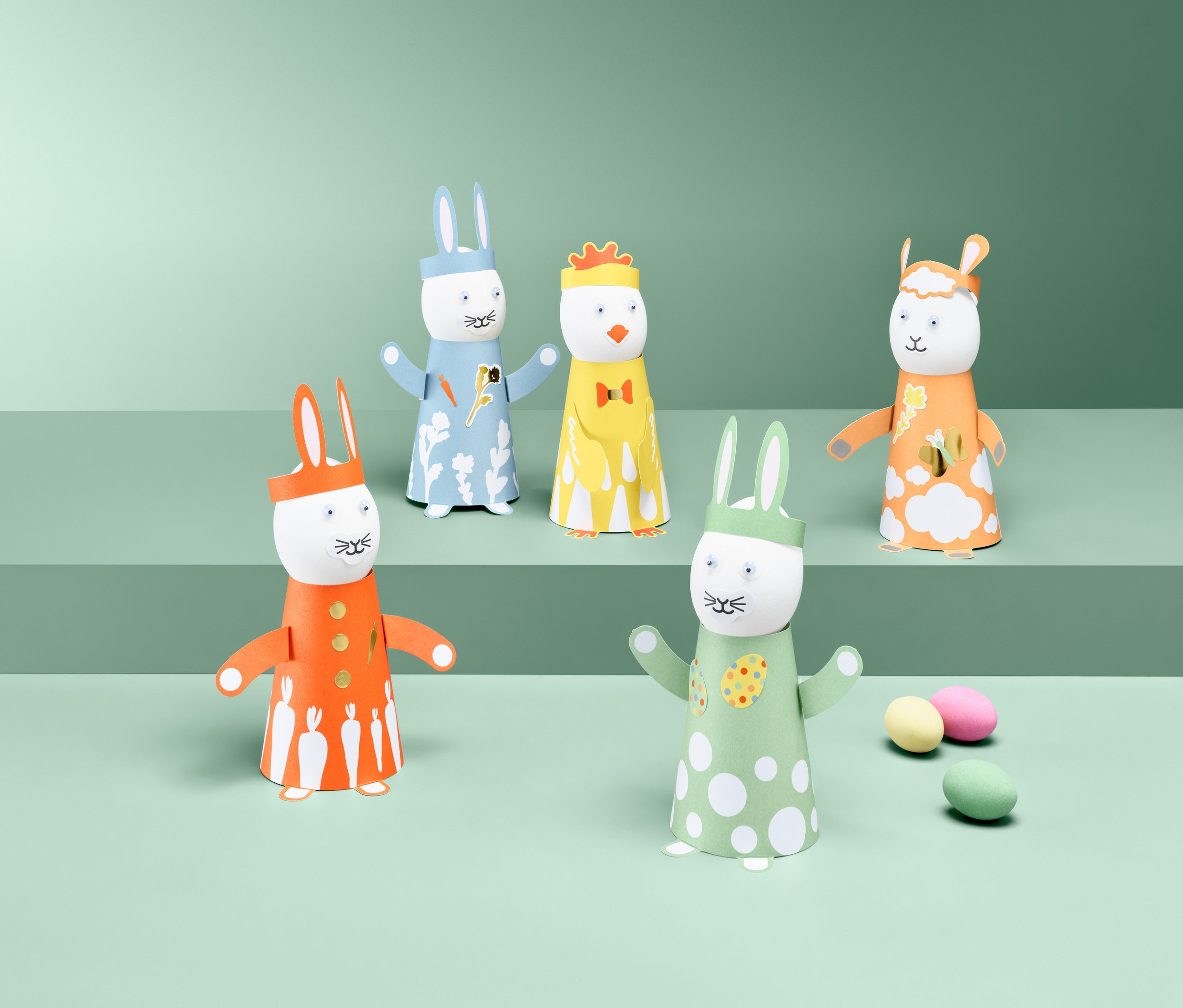 Pięć figurek z Wielkanocnego zestawu kreatywnego stoi na zielonym tle.