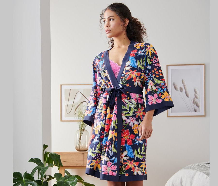 Kobieta ma na sobie szlafrok kimono w kwiatowy wzór.
