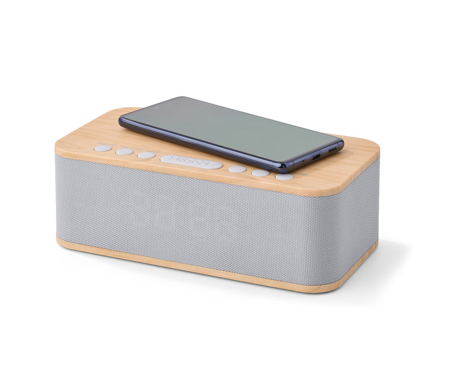 Telefon leży na budziku z funkcją bezprzewodowego ładowania i Bluetooth®.