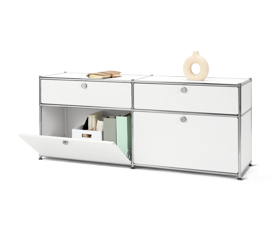 Biała szafka typu sideboard „CN3” z szufladami i drzwiami, książką i wazonem.