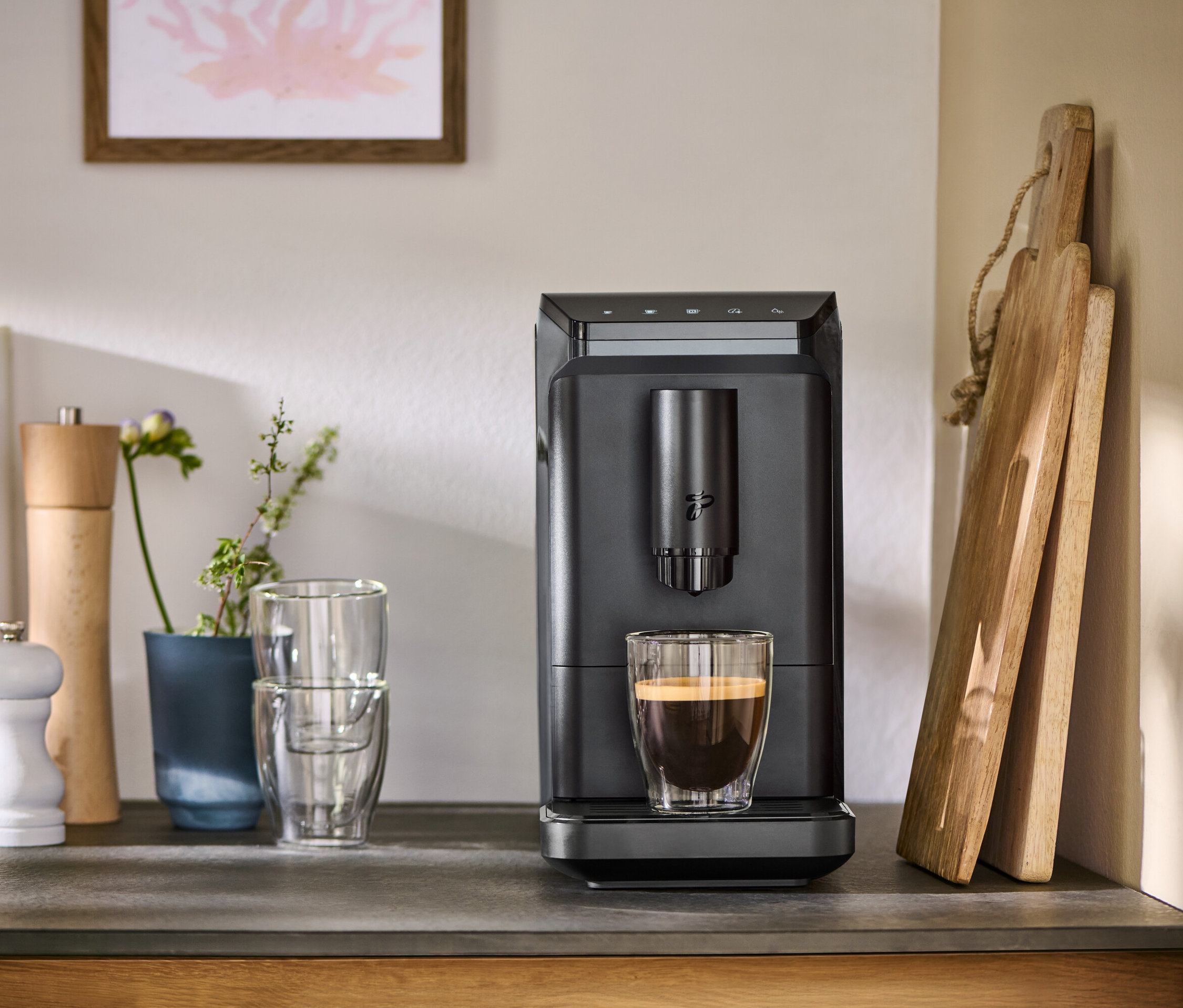 Szary ekspres do kawy »Esperto mini« z filiżanką kawy na blacie.