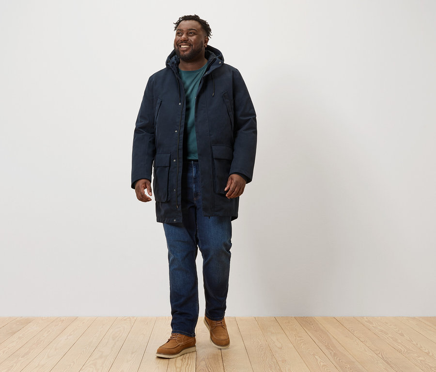 Mężczyzna idzie, ubrany w granatową parkę.