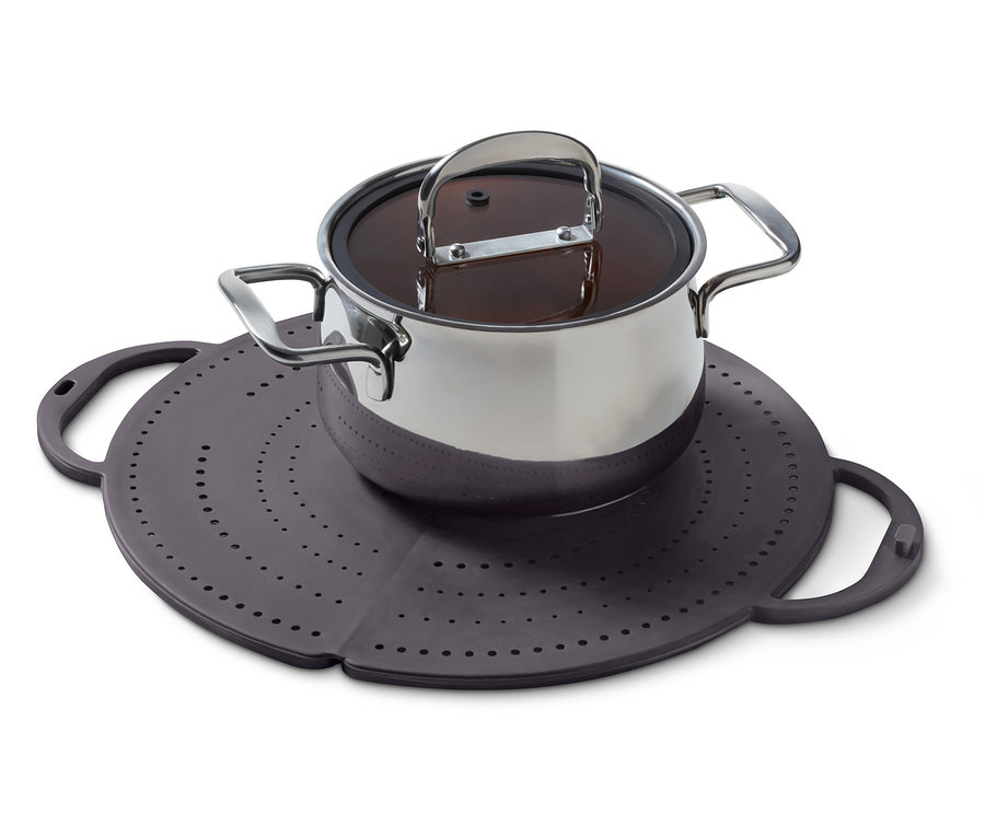 Garnek ze stali nierdzewnej z pokrywką stoi na fioletowej silikonowej podkładce z otworami.