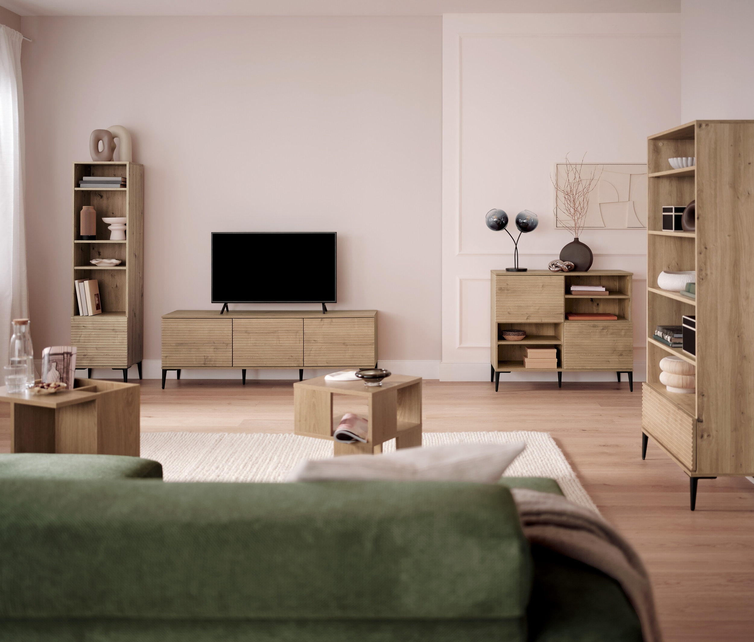 Salon z telewizorem, regałami na książki i stolikami kawowymi.