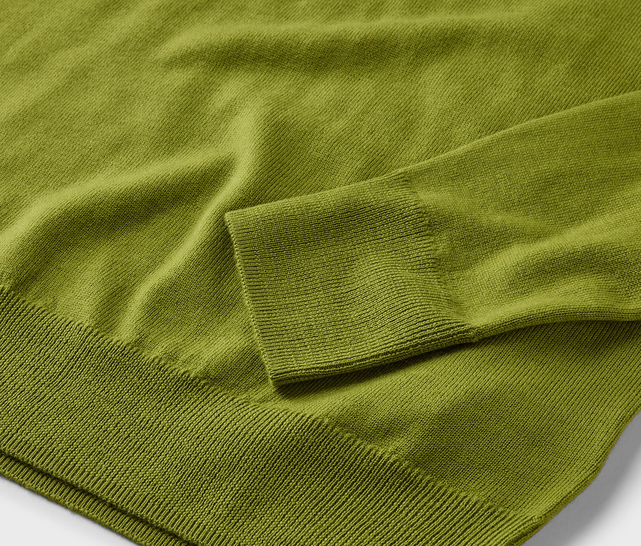 Zbliżenie jasnozielonego swetra z cienkiej wełny merino.