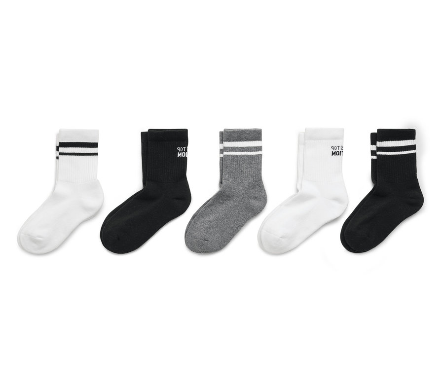 Pięć par skarpet w kolorach białym, czarnym i szarym ułożonych w rzędzie.