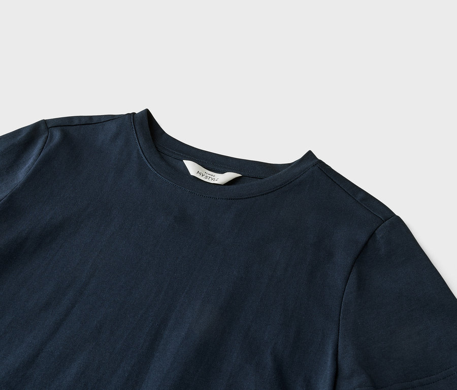 Zbliżenie granatowej koszulki z białym napisem "ICHIBO MY STYLE" na kołnierzyku, leżącej na jasnoszarym tle.