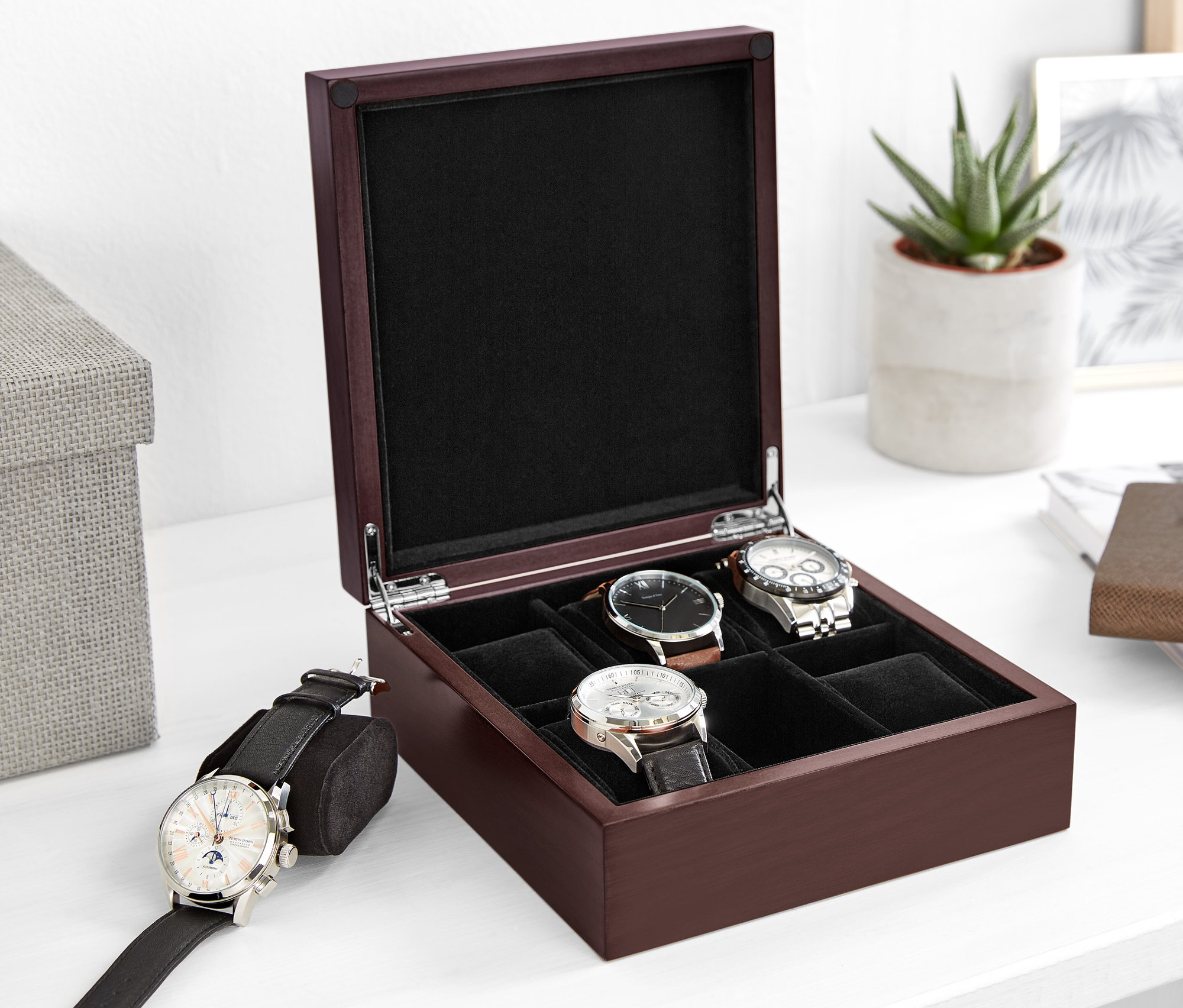 Otwarty drewniany kasetka na zegarki z kilkoma zegarkami w środku.