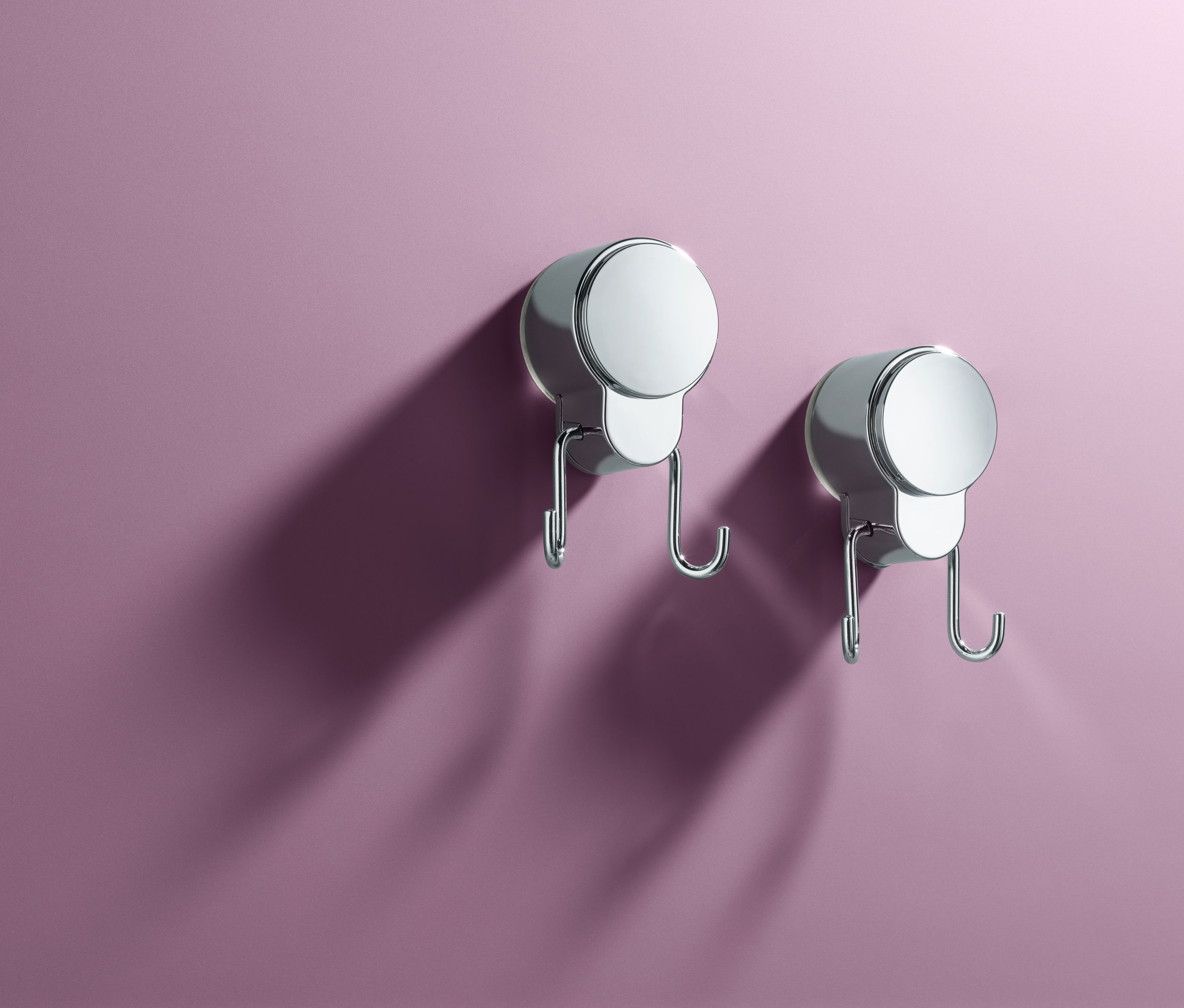 Dwa podwójne haczyki z przyssawkami na fioletowej ścianie.