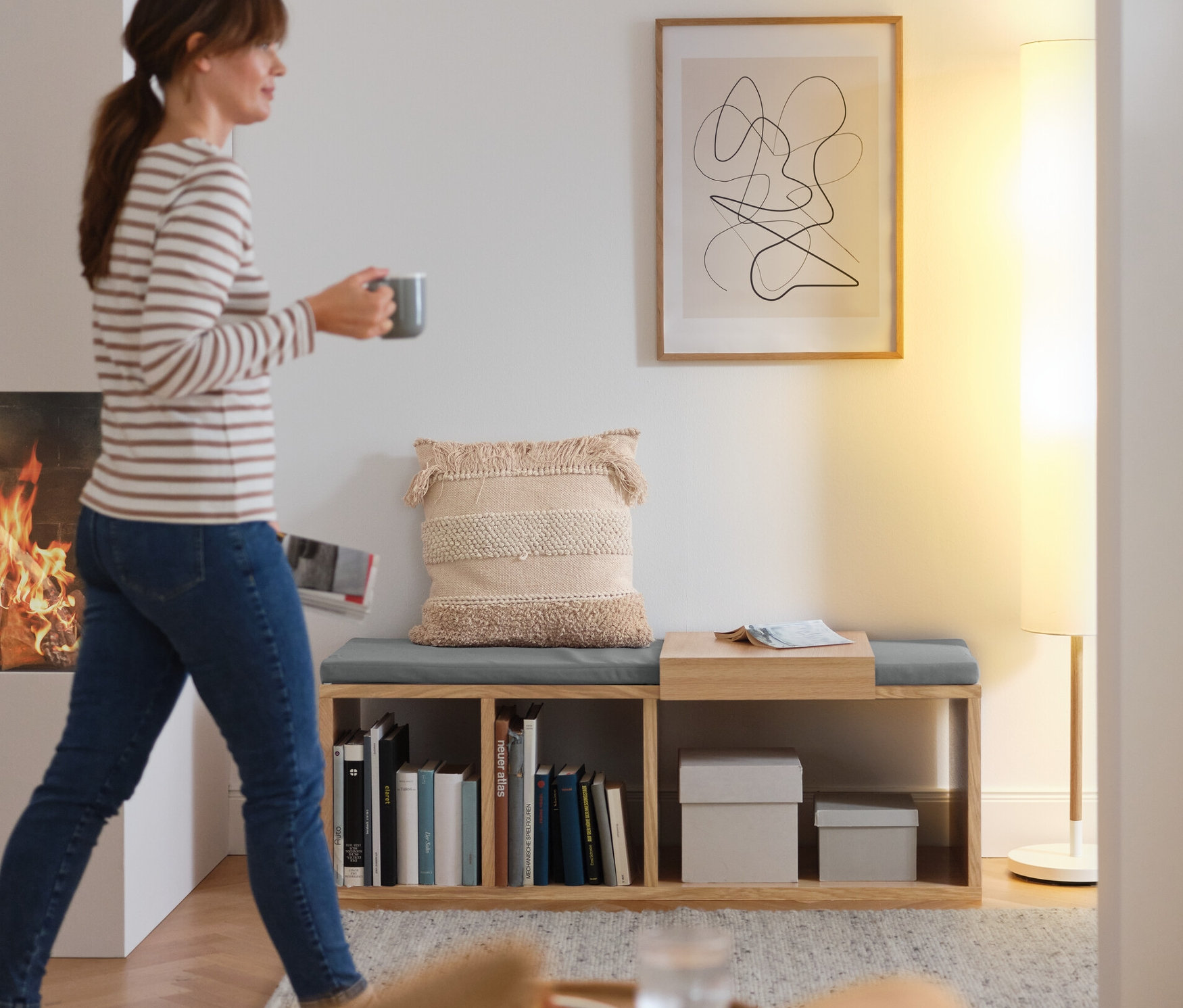 Kobieta z filiżanką przechodzi obok ławki z tapicerką.