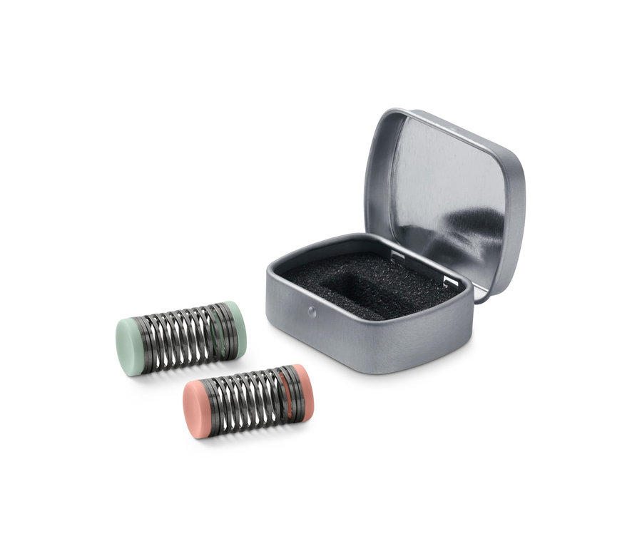 Dwa mini depilatory do twarzy obok otwartego srebrnego pudełka.