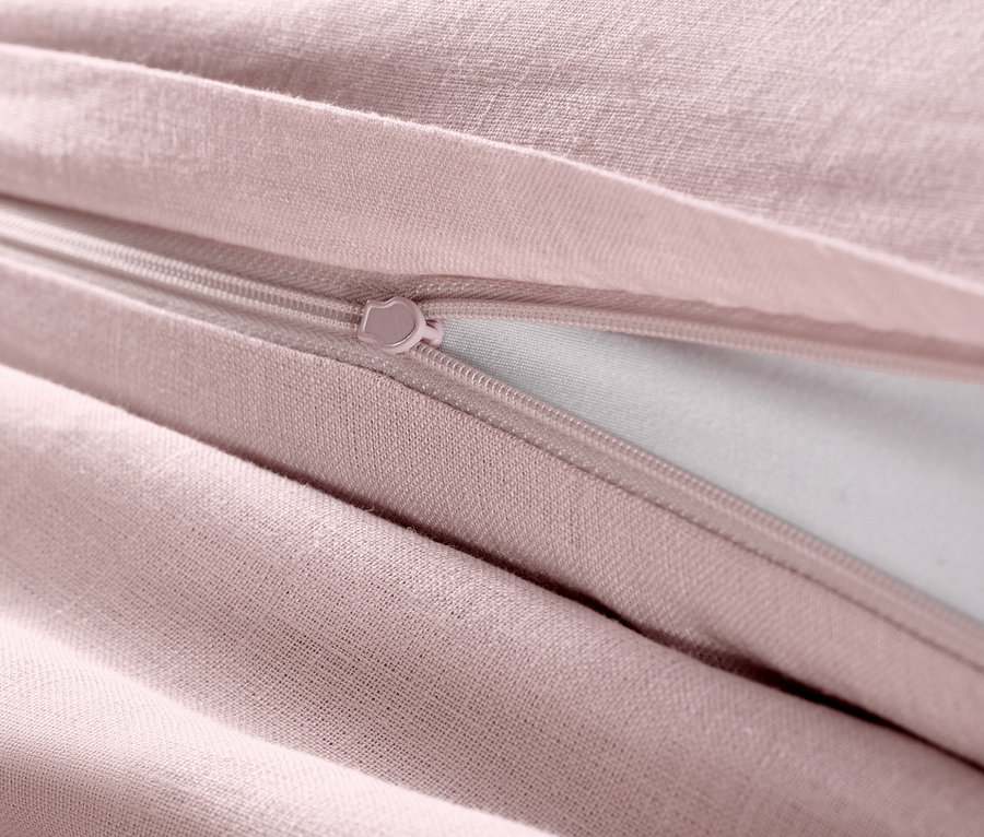 Zbliżenie na różową pościel lnianą z zamkiem błyskawicznym.