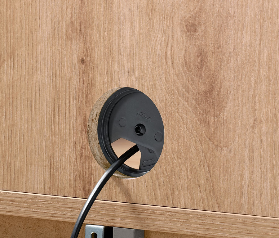 Zbliżenie na otwór na kabel w komodzie 2-drzwiowej.