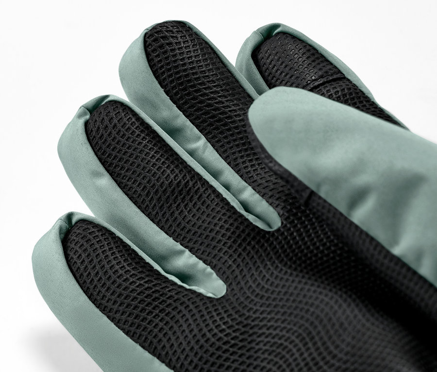 Zbliżenie na zielone dziecięce rękawiczki narciarsko-zimowe.