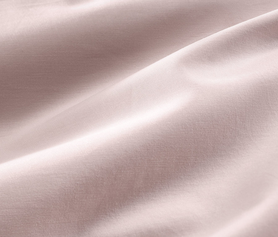 Zbliżenie na bladoróżową pościel z satyny bawełnianej w rozmiarze standardowym i niestandardowym.