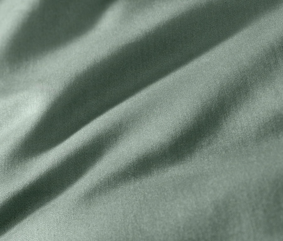 Zbliżenie na zieloną pościel z satyny bawełnianej.