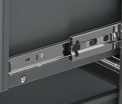 Detal szarego metalowego mebla CN3 z szufladą i metalowymi szynami.