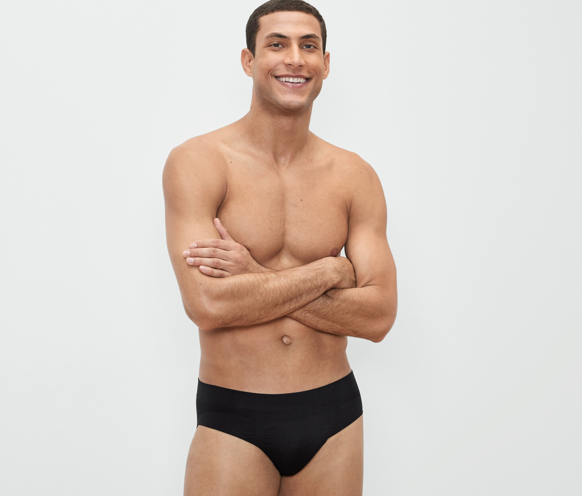 Mężczyzna pozuje ze skrzyżowanymi rękami w czarnych slipach bezszwowych, 3 pary.