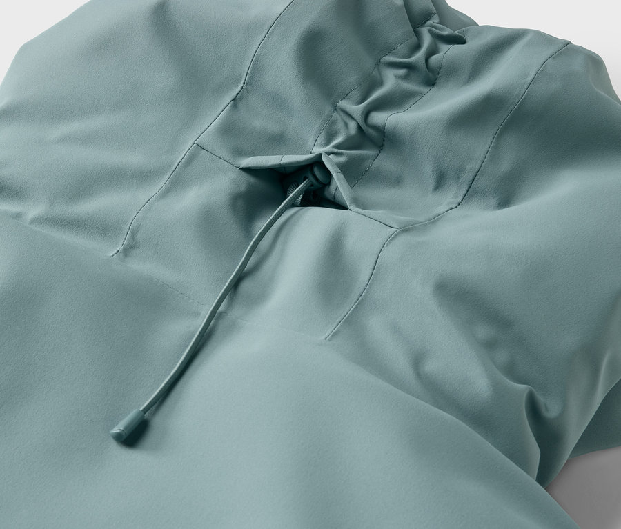 Szczegół jasnoniebieskiej kurtki z kapturem ze sznurkiem.