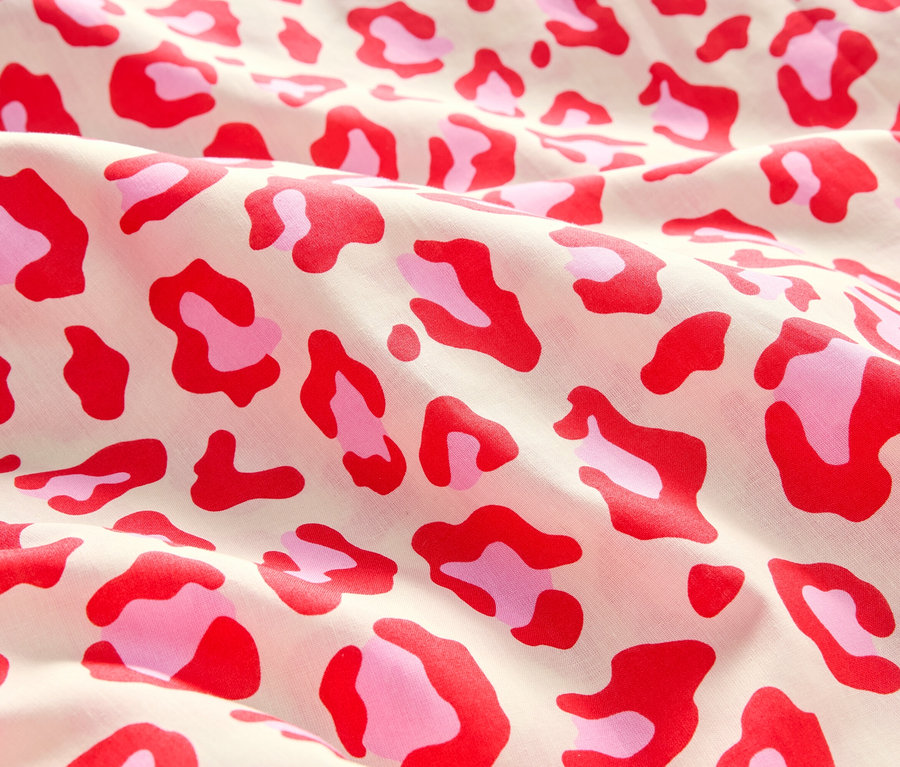 Zbliżenie tkaniny z czerwonym i różowym wzorem w cętki.